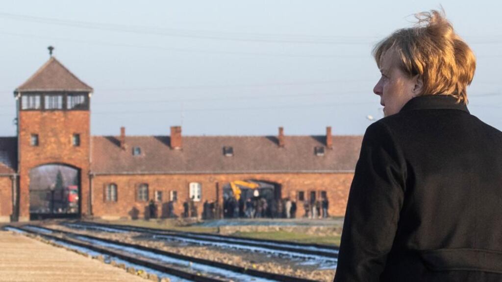 German chancellor Angela Merkel walks past the main railway entrance at the Birkenau camp as she visits the former Nazi death camp Auschwitz-Birkenau in Oswiecim, Poland on December 6th. Photograph: John MacDougall/AFP via Getty