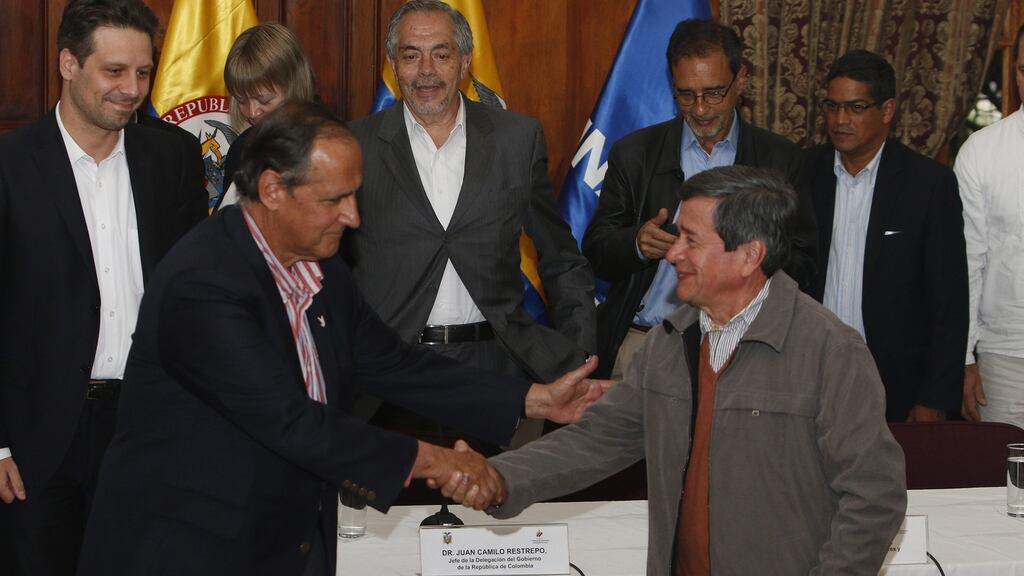 Colombia’s negotiator chief Juan Camilo Restrepo (left) shakes hands with ELN’s Pablo Berltan: the group has kidnapped hundreds of people over its 52 years to raise war funds. Photograph: Rolando Enriquez/EPA