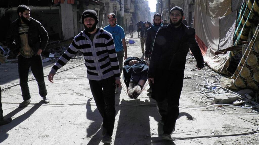 Civilians carry an elderly man, with a serious health condition, on a stretcher towards a meeting point to be evacuated from a besieged area of Homs yesterday. Photograph: Reuters