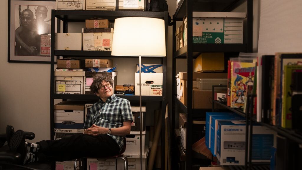Filmmaker Vivian Kleinman sits among stacks of comics and other reference materials for her work in her office in Berkeley, California.
