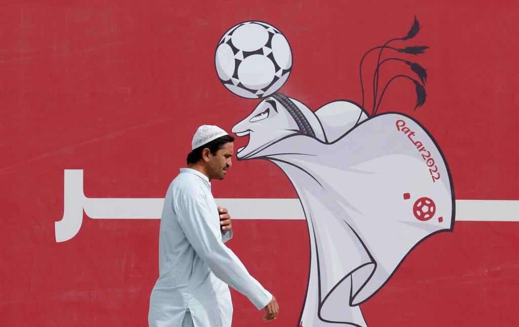 A man walks past a poster of the Qatar 2022 World Cup mascot La'eeb in Doha. Staging the world's biggest football event has cost the 300,000 Qatari citizens an estimated €225 billion. Photograph: Odd Andersen/AFP via Getty Images