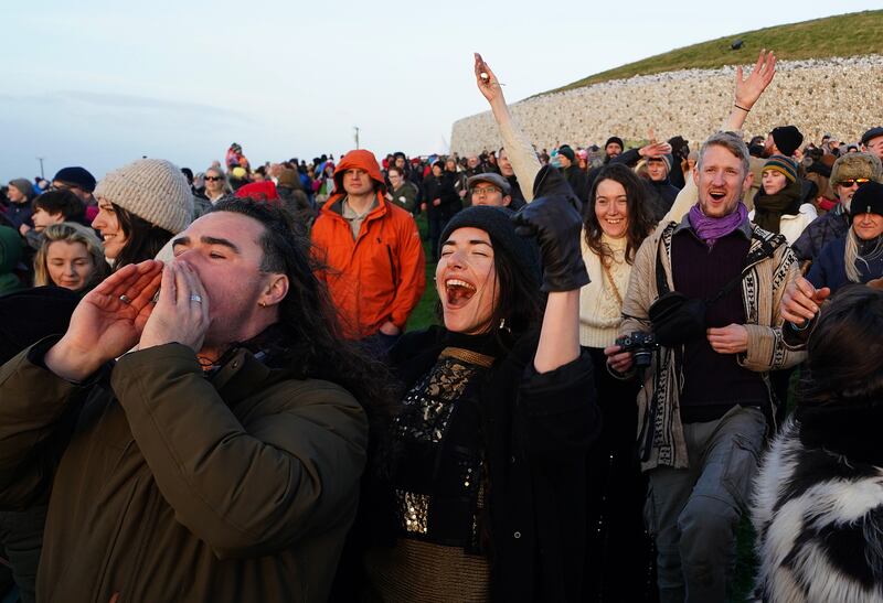 People celebrate the sun rising as they gather at Newgrange. Photograph: Brian Lawless/PA Wire