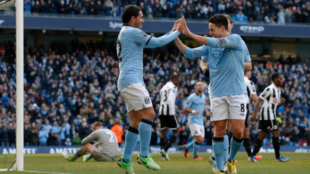 Manchester City's Carlos Tevez celebrates with Samir Nasri after scoring during their clash with Newcastle United at the Etihad Stadium. Photograph: Phil Noble/Reuters.
