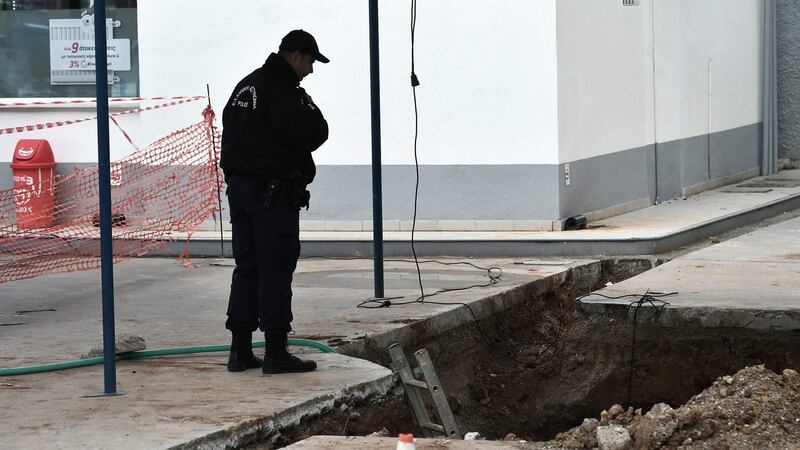 A policeman looks at the hole where an unexploded bomb dating from the second World War was found during work to expand a petrol station in Thessaloniki. Photograph: AFP/Getty Images