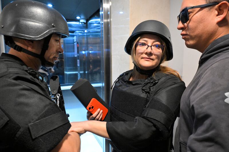 Veronica Sarauz, wife of slain Ecuadorean presidential candidate Fernando Villavicencio, wears a protective helmet and a bulletproof vest while being escorted after a press conference in Quito. Photograph: Rodrigo Buendia/AFP/Getty Images