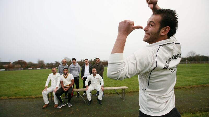 Abdullah Al Jaber shows off his Ballaghaderreen Cricket Club top, with colleagues in the background. Photograph: Brian Farrell