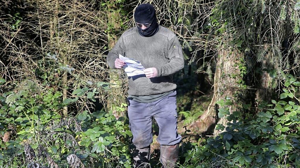 A masked man was photographed with a statement threatening directors of Quinn Industrial Holdings (QIH) this week. Photograph: Courtesy of the Irish News