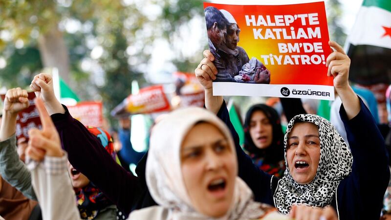 Protesters in Istanbul hold placards reading, ‘Massacre in Aleppo, theatre in the UN’, as they pray for victims of Russian air strikes in Syria. Photograph: EPA/Sedat Suna