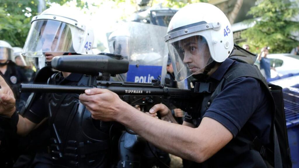 A Turkish riot policeman shoots plastic bullets at protesters during a protest against the government yesterday after the mine explosion in Soma. EPA/Tolga Bozoglu