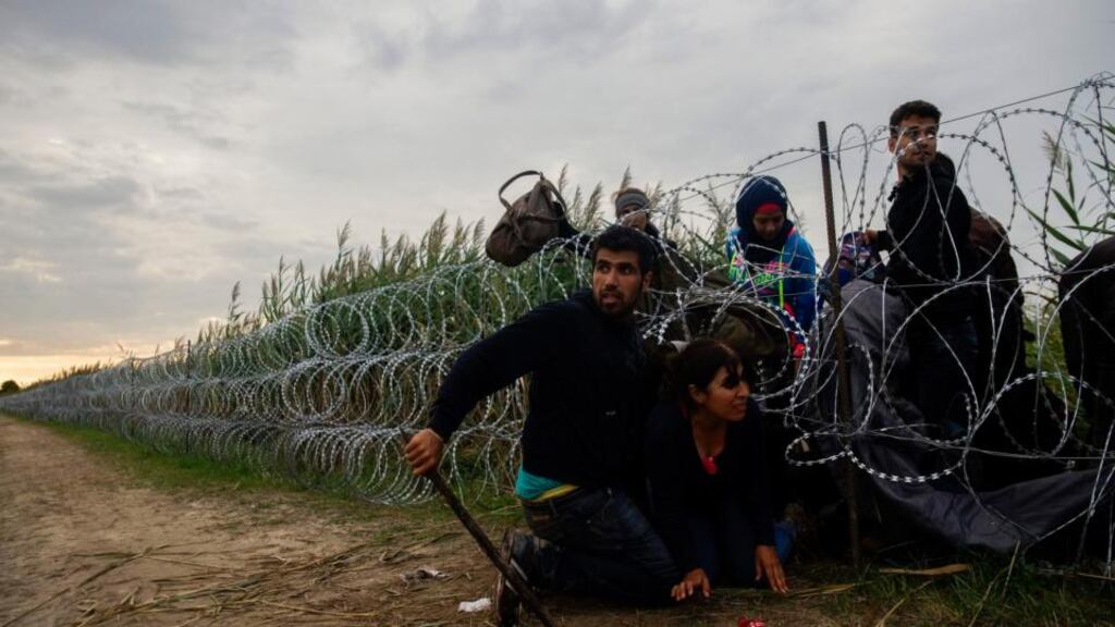 Migrants cross a wire fence at the border between Hungary and Serbia near Roszke, 180km southeast from Budapest. Photograph: Zoltan Balogh/MTI via AP