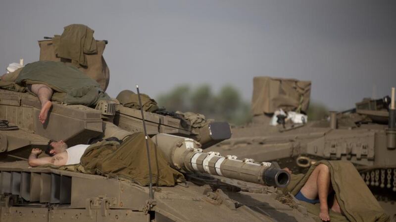 Israeli soldiers sleep on a tank in a deployment area on Israel’s border with the Gaza Strip. Israel’s Operation Protective Edge entered its sixth day on Sunday, as the death toll in Gaza mounted to more than 160 Palestinians, while the international community stepped up pressures to reach a cease-fire. Photograph: Lior Mizrahi/Getty Images