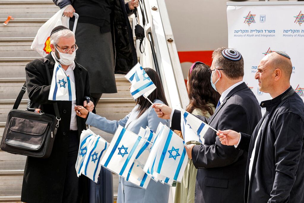 Israeli flags are handed out to immigrants from Ukraine disembarking from their aircraft at Israel's Ben Gurion Airport in Lod in February. Photograph: Jack Guez/AFP via Getty