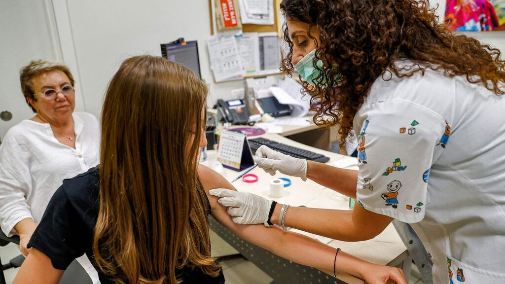 A teenage girl receives a dose of the Pfizer/BioNTech Covid-19 vaccine  in the Israeli city of Holon near Tel Aviv. Photograph:  Jack Guez/AFP via Getty Images