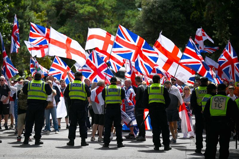 Protesters wave Union Jack and St George's Cross flags at a protest outside a hotel housing asylum seekers in Bournemouth, southern England. Photograph: Finnbarr Webster/Getty