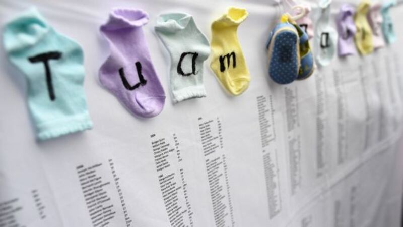 Baby socks and shoes are attached to the list of children names at the site of where the remains of 796 babies where uncovered at a site of a former mother and baby home in Tuam, Co Galway. Photograph: Dylan Martinez/Reuters.