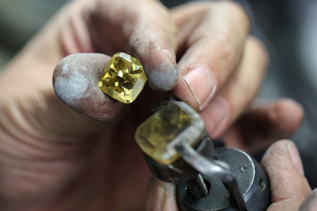 A worker holds a cut diamond in the manual polishing unit at the Antwerp World Diamond Center in Belgium. Some European Union nations want sanctions imposed against the import of Russian stones to the EU but the diamond industry looks likely to be spared for now. Photograph: Valeria Mongelli/Bloomberg
