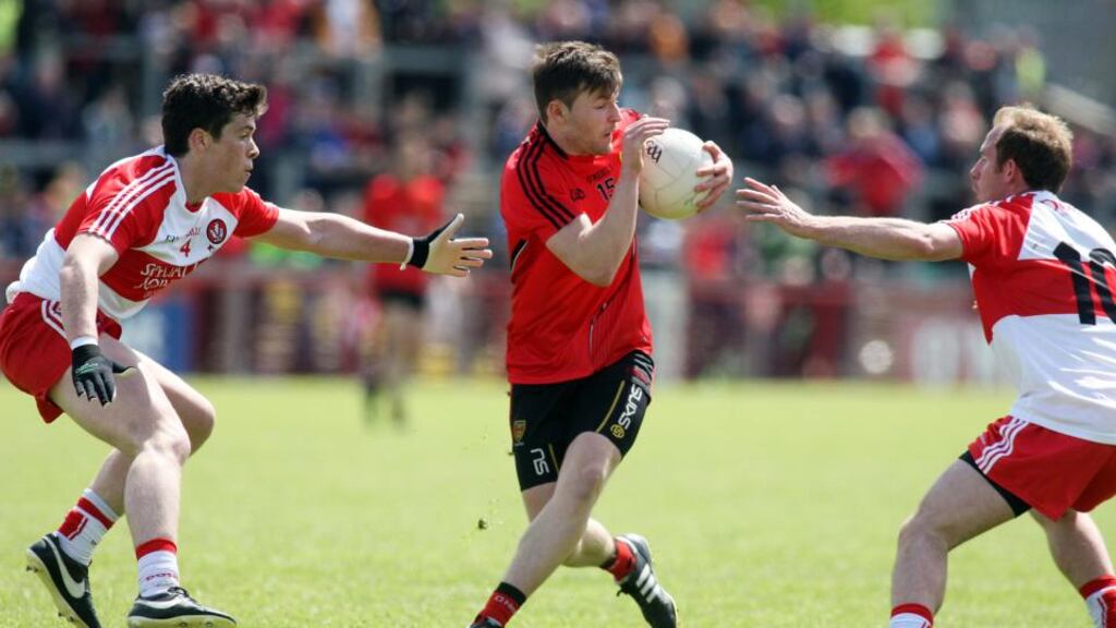 Down’s Donal O’Harewho looks to be fit again, battles against Derry’s Dermot McBride and Sean Leo McGoldrick during the Ulster quarter-finalat Celtic Park, Derry. Photograph: Inpho
