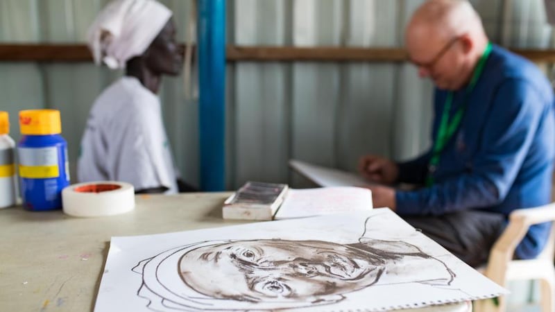 Irish artist Brian Maguire sketches Veronika Meer in the PoC capmp in  Bentiu, South Sudan. Veronika fled here with her kids when conflict broke out in her town and her husband was killed. Photograph: Steve De Neef/Concern Worldwide