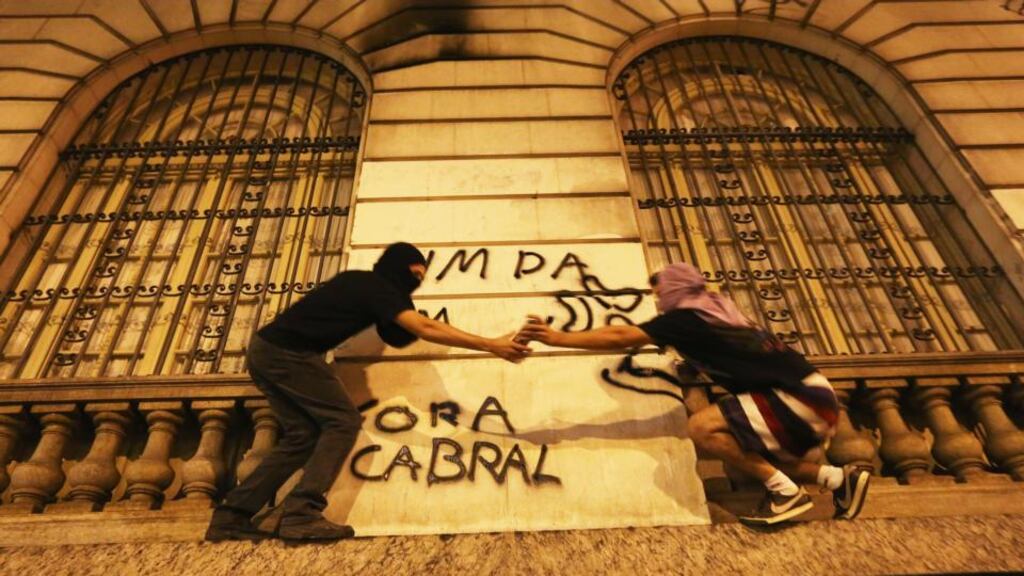 Masked demonstrators spray paint a government building before clashes begin on ‘Teachers’ Day’ at a mostly peaceful protest by teachers and supporters calling for better public education and services. Photograph: Mario Tama/Getty Images