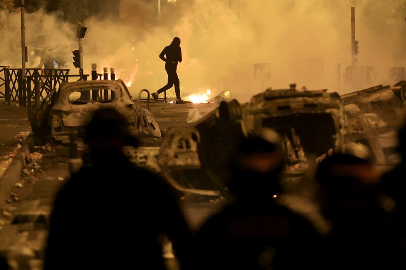 A demonstrator runs on the third night of protests in the Paris suburb of Nanterre. Photograph: Aurelien Morissard/AP