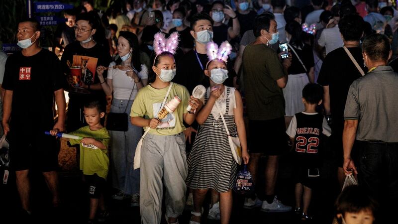 Residents wear masks while walking through the entrance to the Wuhan Beer Festival in China. Photograph: Getty Images