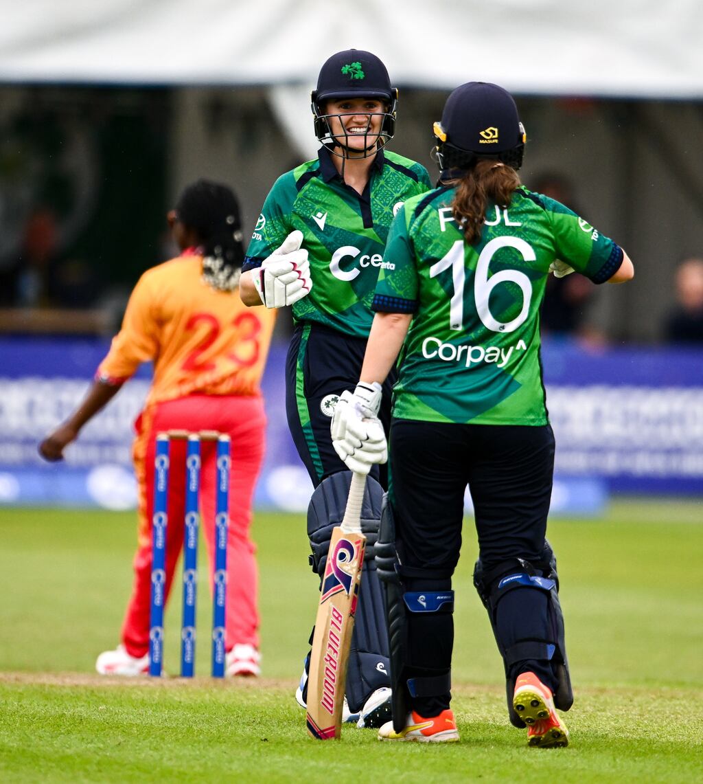 Ireland captain Gaby Lewis celebrates with team-mate Lara Paul after hitting a boundary during the first T20 international against Zimbabwe at Pembroke Cricket Club in Dublin. Photograph: Ben McShane/Sportsfile