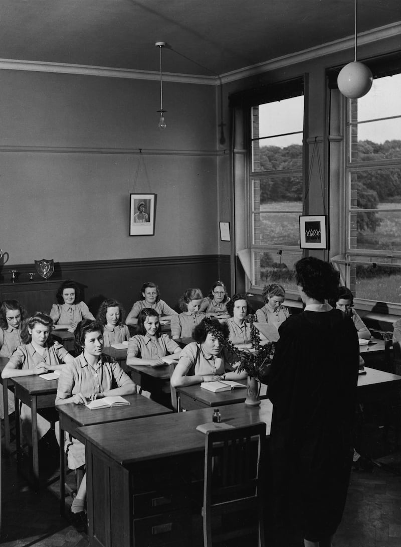 Girls from the Dungannon High School sit in a classroom and listen to their teacher read, County Tyrone, Ireland, circa 1950. Photograph: Hulton Archive/Getty Images