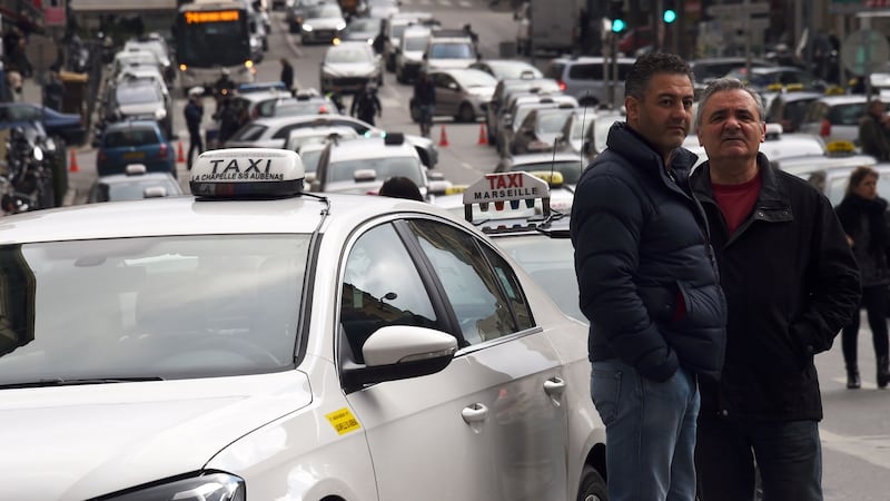 Taxi drivers stand next to their cabs lined up at Castellane Square during a protest against Uber in Marseille, southern France,.