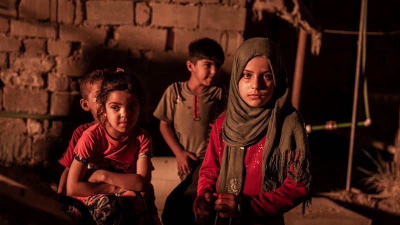 Children in a compound courtyard near flaring oil wells that light the night sky in Nahran Omar in Iraq. Photograph: Ivor Prickett/New York Times