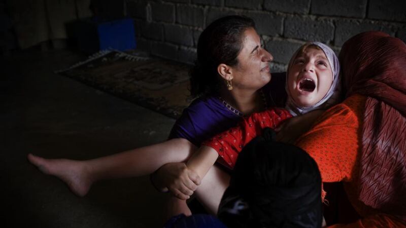 Female genital mutilation: a Kurdish girl screams as a midwife cuts her in 2008; her mother (right) and an escort for the photographer comfort her. Photograph: Andrea Bruce/Washington Post via Getty