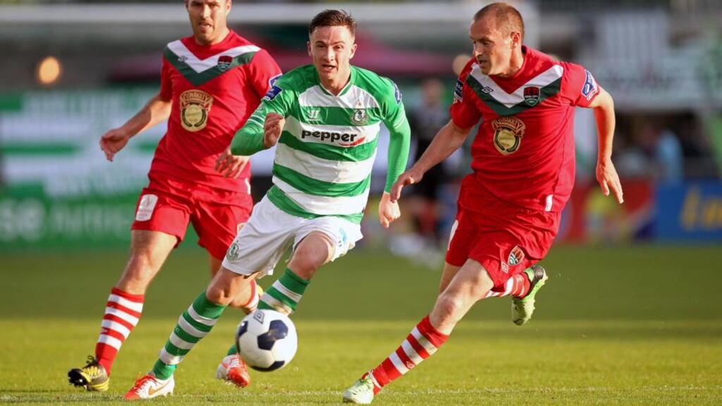 Ronan Finn (centre) of Shamrock Rovers and Cork’s Colin Healy in action during last night’s game at Tallaght Stadium. Photograph: Ryan Byrne/Inpho