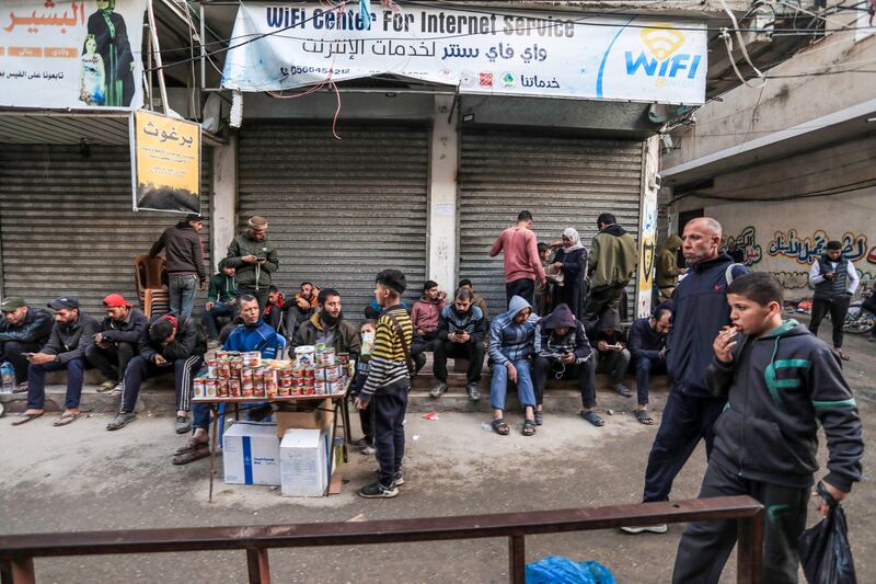 Palestinians use their mobile phones outside a shuttered wifi centre in Deir al-Balah in central Gaza. Photograph: AFP via Getty Images