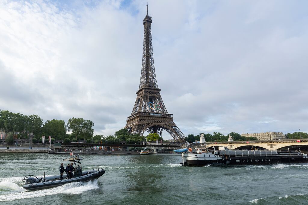 Sightseeing boats and a police rubber dinghy sail on the river Seine. Photograph: Andre Pain