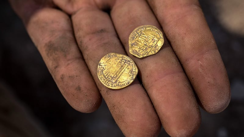 An Israeli archaeologist displays gold coins dating to the Abbasid Caliphate discovered at an archeological site near Tel Aviv. Photograph: Heidi Levine/AFP via Getty Images