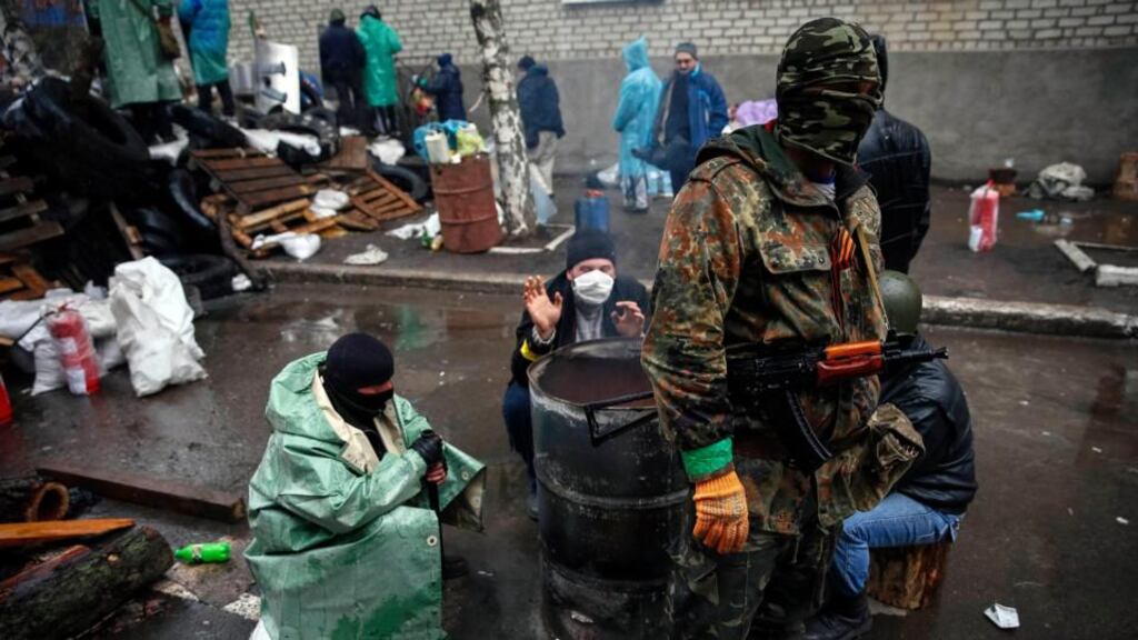 Pro-Russian men gather around a fire at a barricade near the police headquarters in Slaviansk yesterday. Photograph: Reuters/Gleb Garanich