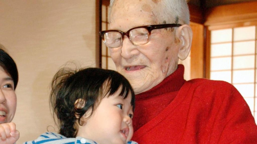 Jiroemon Kimura holds one of his 15 great-great-grandchildren in Kyotango, western Japan, in April 2012. Photograph: Kyodo/Reuters