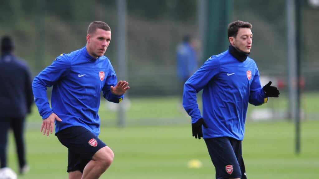 Lukas Podolskia and Mesut Özil (right) of Arsenal warm up during Arsenal training at London Colney. Photograph: Shaun Botterill/Getty Images
