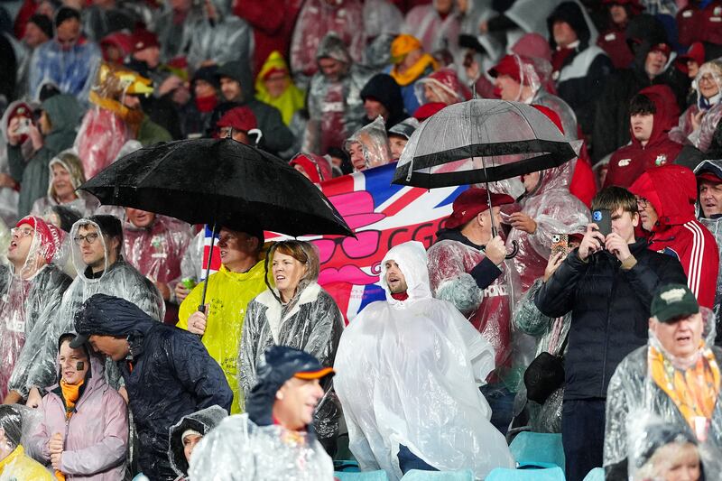 Supporters shelter from the rain under umbrellas at Accor Stadium in Sydney. Photograph: David Davies/PA