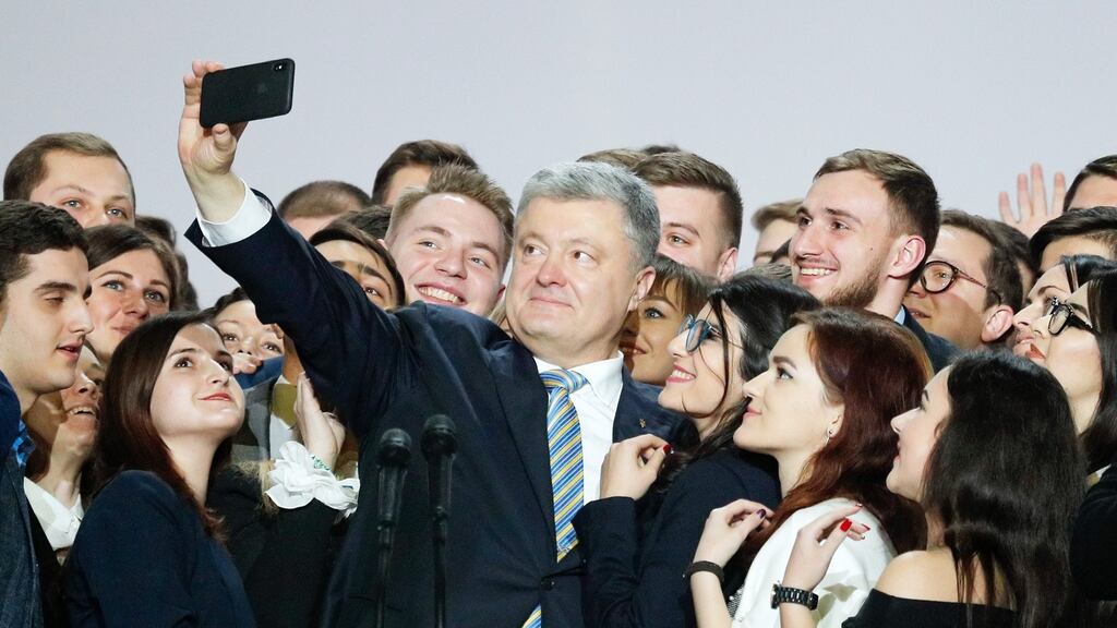 Ukrainian president Petro Poroshenko takes a selfie with students in Kiev after saying he will run again in the next election in March. Photograph: Sergey Dolzhenko/EPA