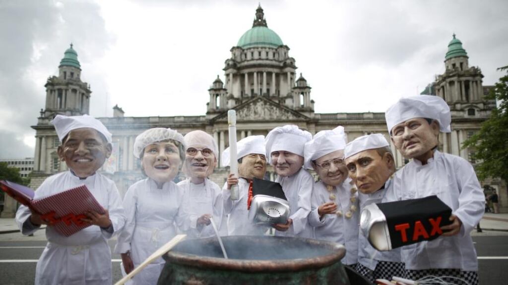 Oxfam charity volunteers wearing masks depicting the G8 leaders   outside Belfast City Hall yesterday.  Photograph:    Peter Macdiarmid/Getty Images