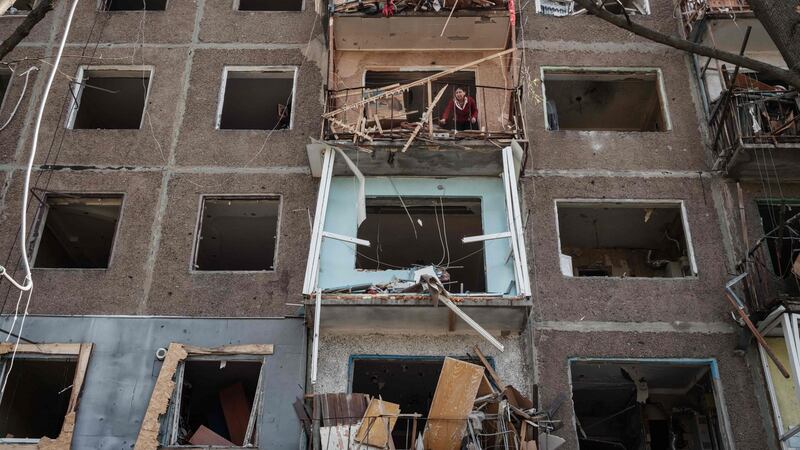 A woman on a balcony cleans her room at an apartment damaged by a missile explosion in Kramatorsk, eastern Ukraine. Photograph: Yasuyoshi Chiba/AFP via Getty Images