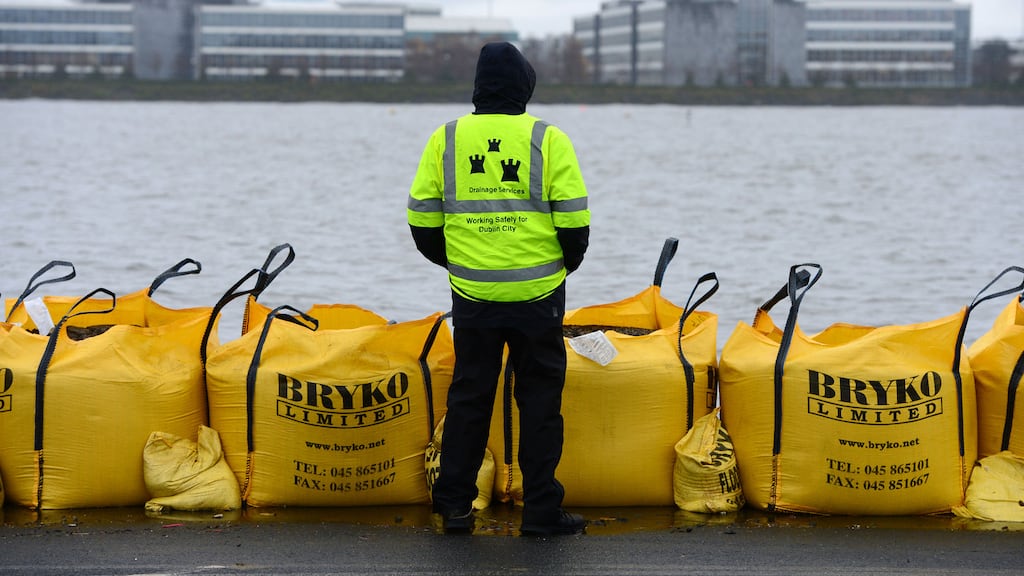 A Dublin City Council worker keeps watch on flood defence barriers along the Clontarf seafront as a very high tide poses a risk of flooding in December 2012. Photograph: Alan Betson/The Irish Times