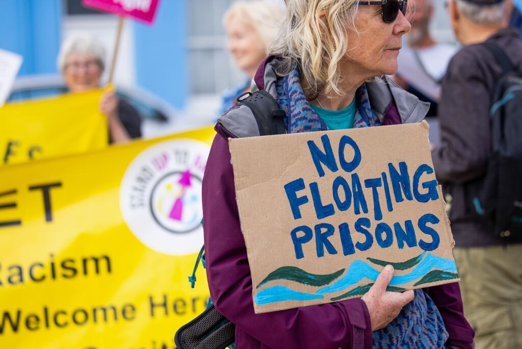 A protestor at Portland Port in the UK following the arrival of a barge that can house 500 migrants in July. Photographer: Chris Ratcliffe/Bloomberg