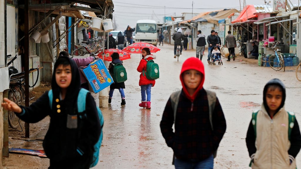 Syrian refugee children walk to  school during rainy weather at  Al Zaatari refugee camp in  Jordanian city of Mafraq, near  border with Syria. Photograph:  Muhammad Hamed/Reuters