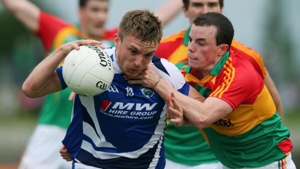 Carlow’s Barry-John Molloy tackles Ross Munnelly of Laois. Photograph: Lorraine O’Sullivan/Inpho