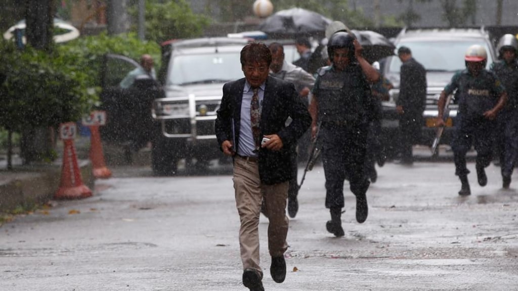 A Japanese official take cover after visiting the Holey Artisan Bakery, site of the June 2nd massacre in Dhaka. Photograph: Reuters/Adnan Abidi
