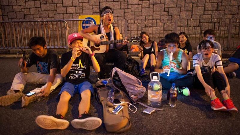 Protesters play music on a street outside the Hong Kong government complex yesterday as thousands of pro-democracy supporters continued to occupy the streets surrounding the city’s financial district. Photograph: Anthony Kwan/Getty Images