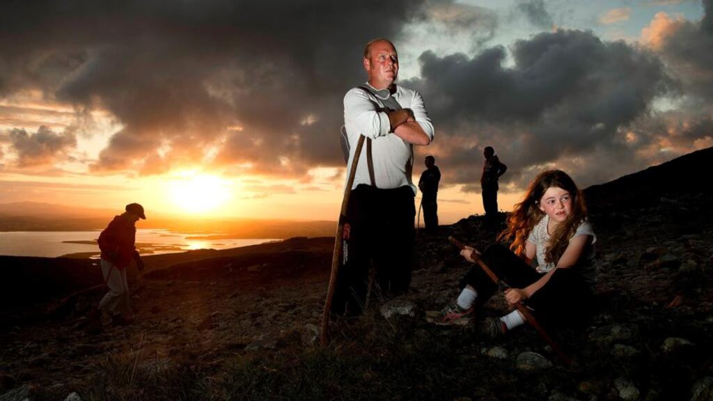 Pilgrims Shauna (9) and her dad Ray Murphy, Devlin, Louisburgh, Co.Mayo take a break as they Make their way up Croagh Patrick at dawn for the annual Reek Sunday pilgrimage. Pic: Michael Mc Laughlin