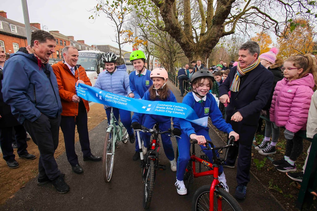 Minister for Environment Eamon Ryan, Cllr Naoise Ó Muirí and Minister for Public Expenditure Paschal Donohoe look on as Irina Diaconu, Wiktoria Bosowska, Zoe Campbell and Peggy-Rose Rowan from St Mary's Fairview conduct the inaugural cycle on the Clontarf to city centre cycle path. Photograph: Chris Bellew