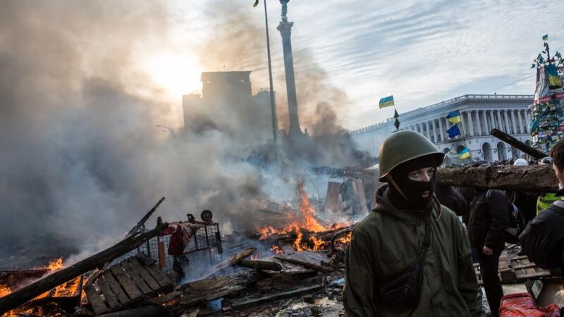 Anti-government protesters walk amid debris and flames near the perimeter of Independence Square, known as Maidan, in Kiev, Ukraine this morning. Photograph: Brendan Hoffman/Getty